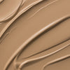 Nahaufnahme der cremigen Textur des Yummy Skin Lift & Flex Concealer 3 in warmem Beige.