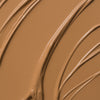 Nahaufnahme der cremigen Textur des Yummy Skin Lift & Flex Concealer 9 in warmem Hellbraun.