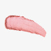 Rosa schimmernder Farbstreifen des Yummy Skin Blurring Balm Powder Lowlighter Unbothered auf weißem Hintergrund.