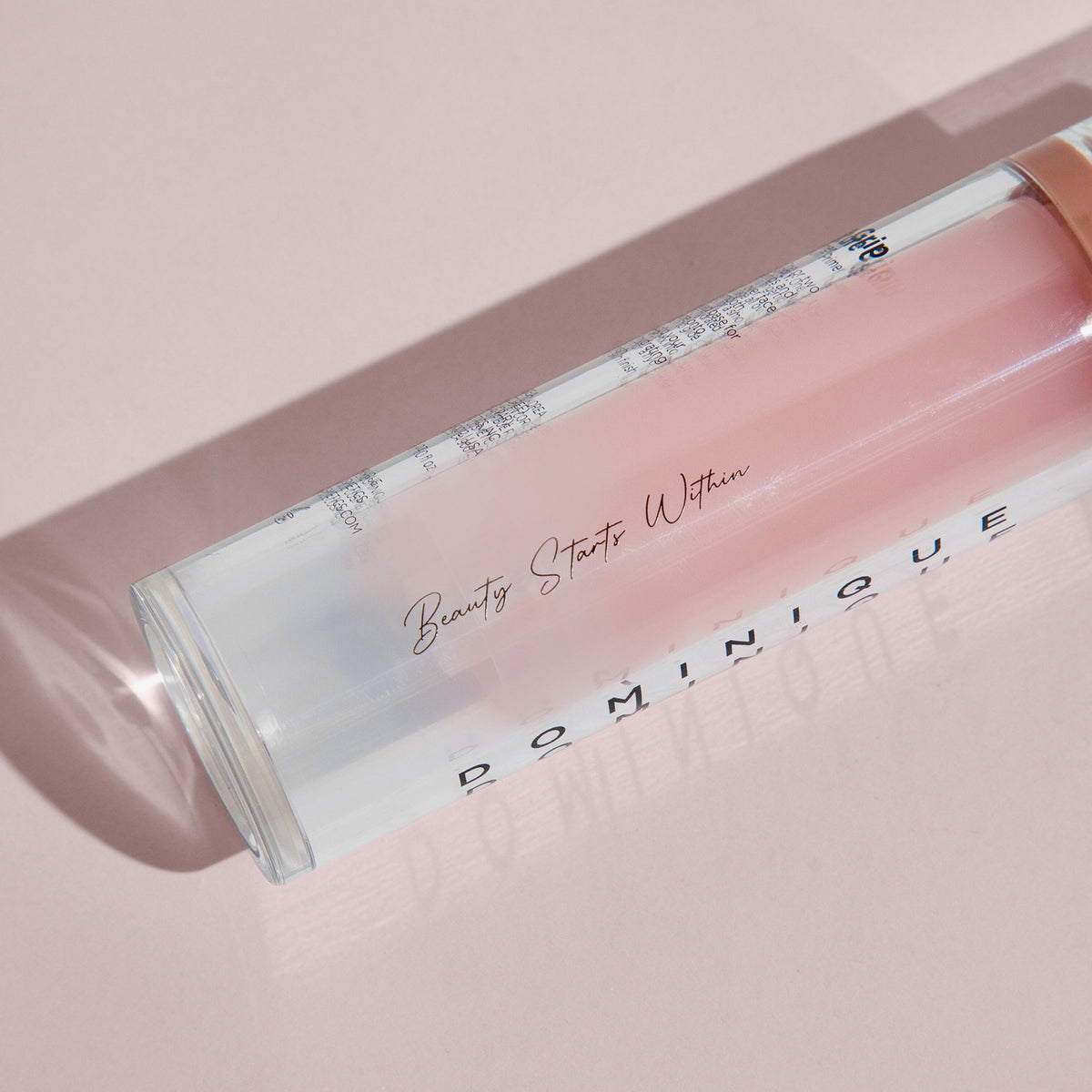 Auf einer hellrosa Oberfläche liegt der Moisture Grip Serum Primer mit der Aufschrift „Beauty Starts Within“.