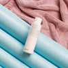 Eine Flasche Water Killer Trockenshampoo auf einem blau-rosa Hintergrund.