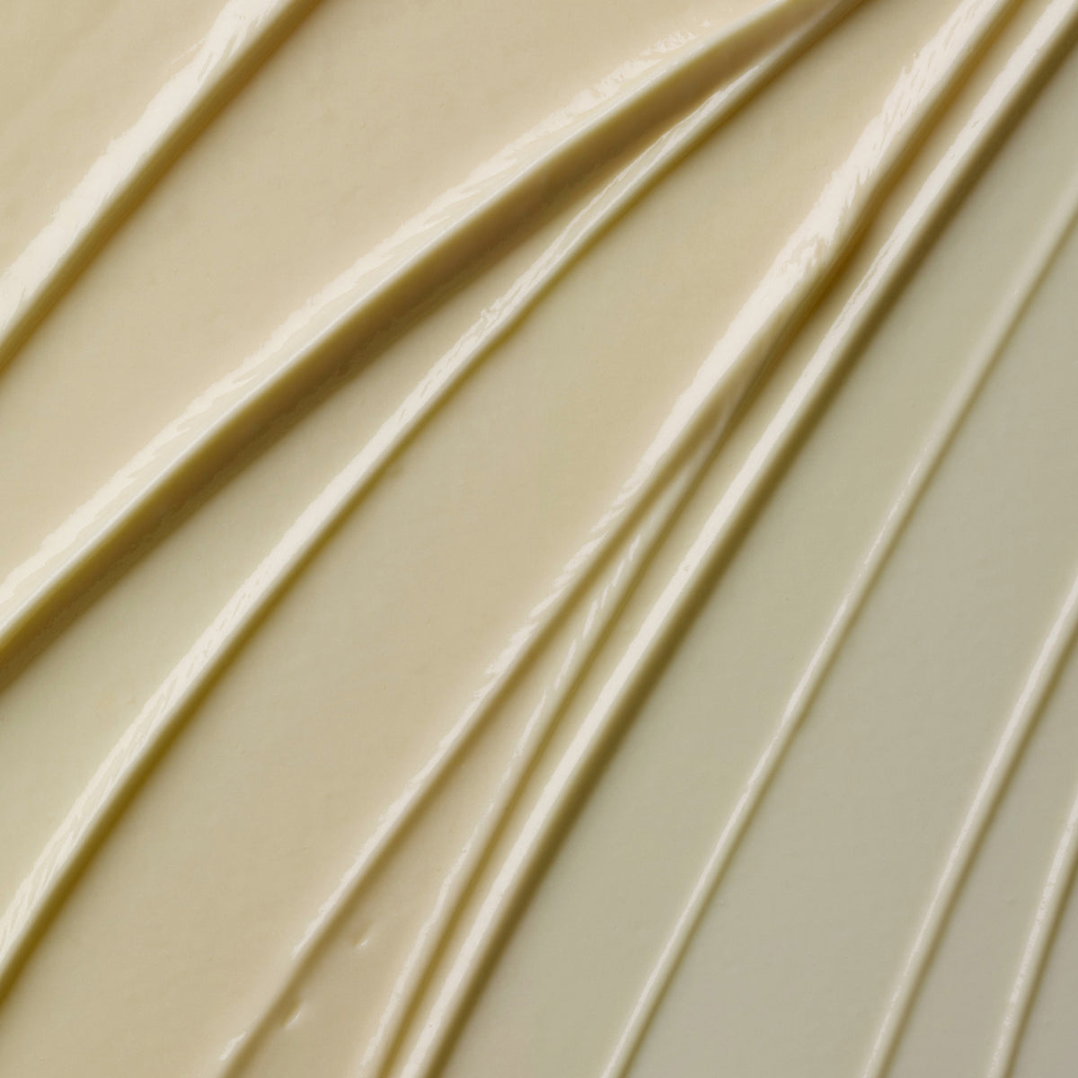 Nahaufnahme der cremigen beigen Textur des Glow-C Daily Moisturiser mit strukturierten, gewellten diagonalen Linien.