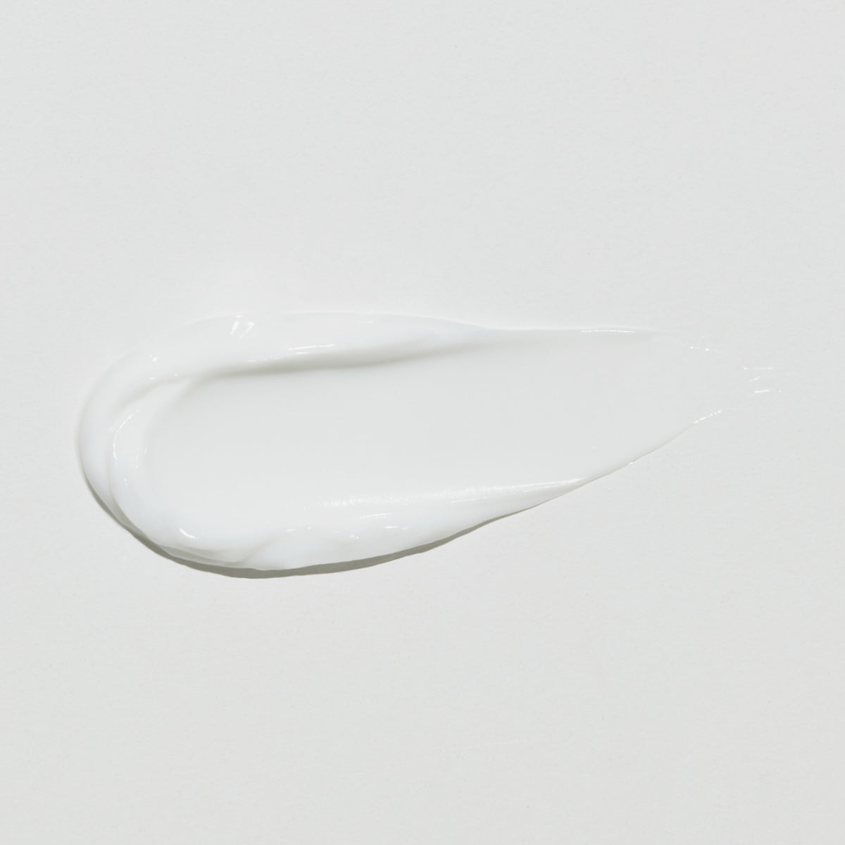Ein weißer Klecks Collagen Peptide Eye Cream auf einem schlichten weißen Hintergrund.