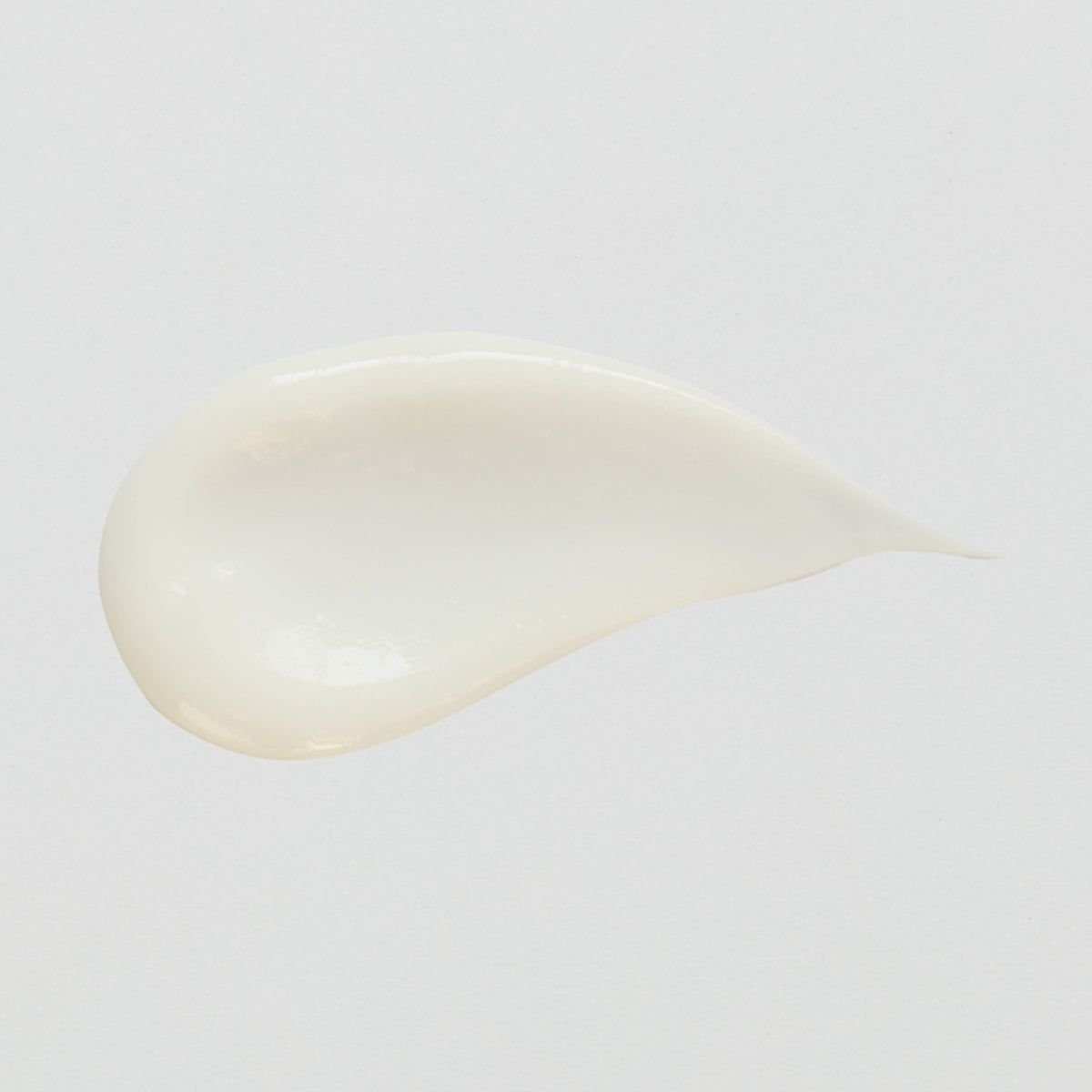 Ein glatter, cremiger Fleck Vitamin A Glow Retinol Serum auf einem schlichten weißen Hintergrund.