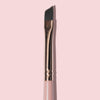Nahaufnahme des K26: Eyeliner Brush mit abgewinkeltes Design, rosa Griff und goldener Zwinge, abgebildet vor einem blassrosa Hintergrund.
