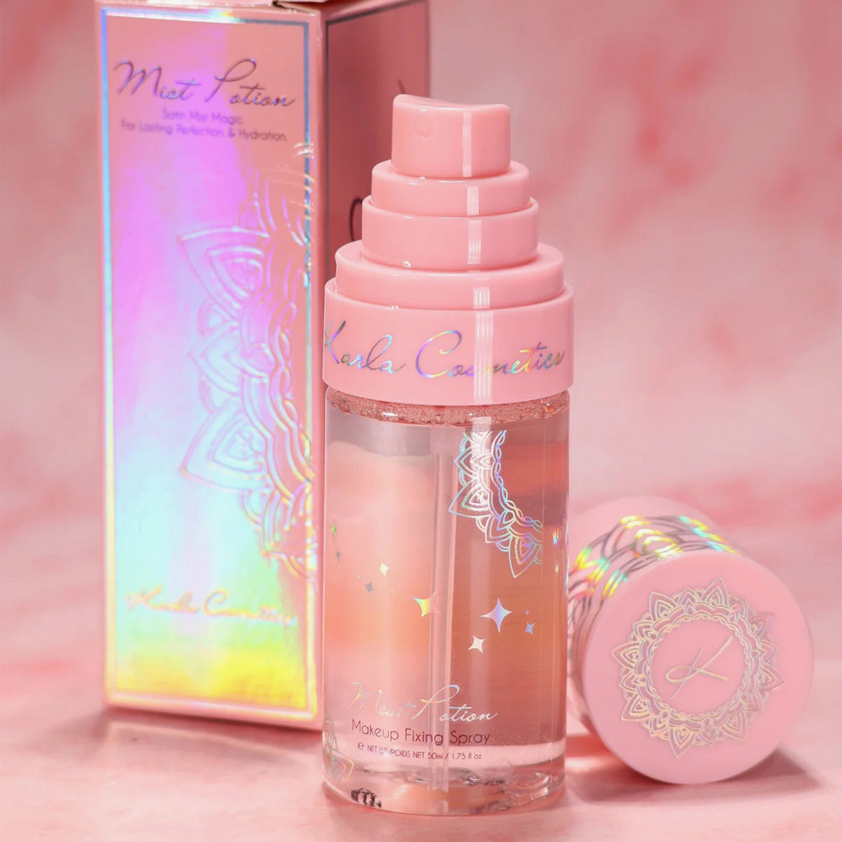 Eine rosa Flasche Mist Potion – All-in-One Eyeshadow & Makeup Primer + Setting Mist von Kala Cosmetics, mit schillernder Verpackung.