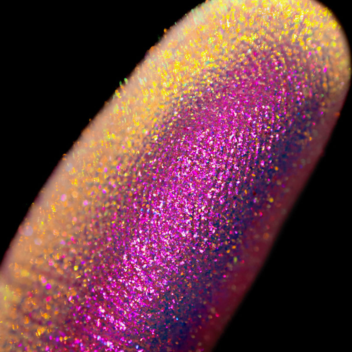 Nahaufnahme einer Fingerspitze, die in den Opal Moonstone Loose Multichrome Eyeshadow Drama Queen getaucht wurde und rosa-violett glitzert.