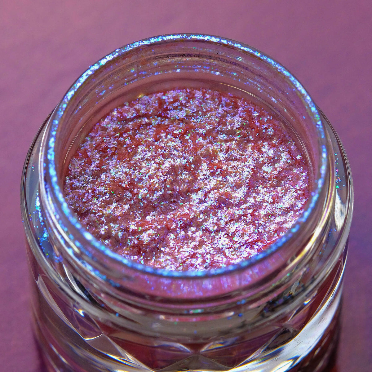Nahaufnahme der Textur des des Opal Moonstone Loose Multichrome Eyeshadow Moody Cow; ein rosa-bläulich schimmerndes Pigment.