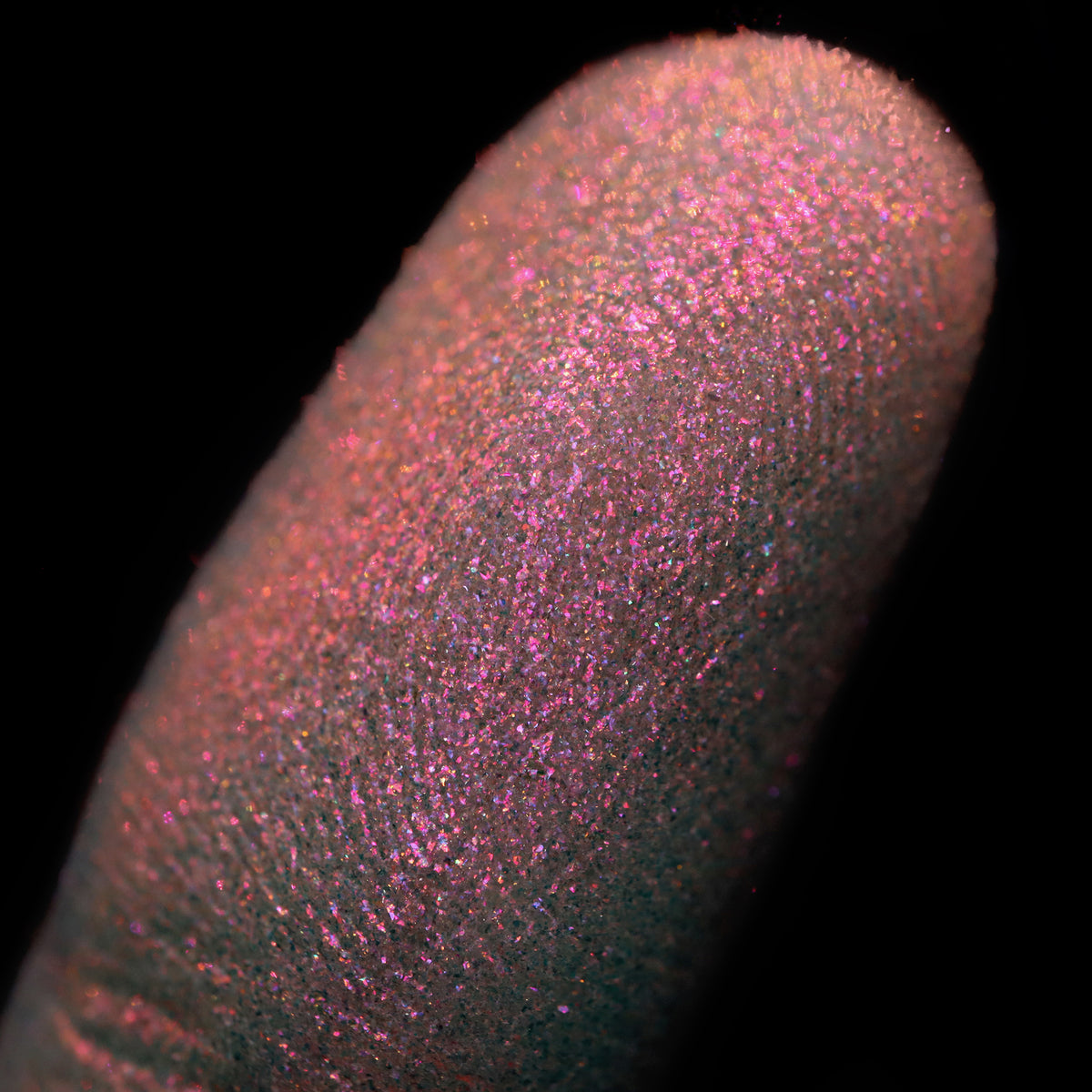 Nahaufnahme einer Fingerspitze, die in den Opal Multichrome Loose Eyeshadow Skylight getaucht wurde und pink-orange glitzert.