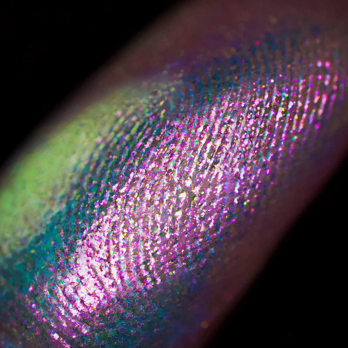 Nahaufnahme des seidigen Opal Shadow Potion Silky Gel Eyeshadow Rockabye Baby; grün und lila schimmernd auf der Haut.