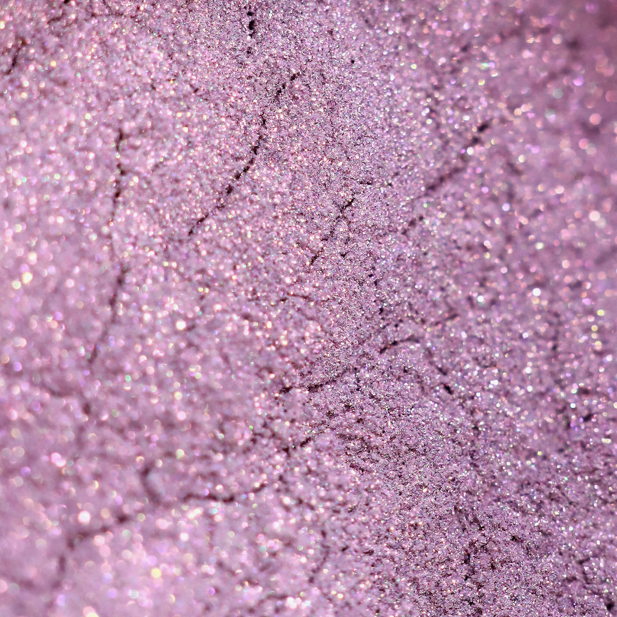 Nahaufnahme der Textur des Pastel Duochromes Loose Eyeshadow Cupcake; ein hellviolett schimmerndes Pigment.