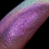 Nahaufnahme einer Fingerspitze, die in den Pastel Duochromes Loose Eyeshadow Dolly getaucht wurde und lila und rosa glitzert.