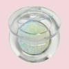 Kompaktdose des Pressed Opal Multichrome Eyeshadow Beauty Sleep auf blassrosa Hintergrund.