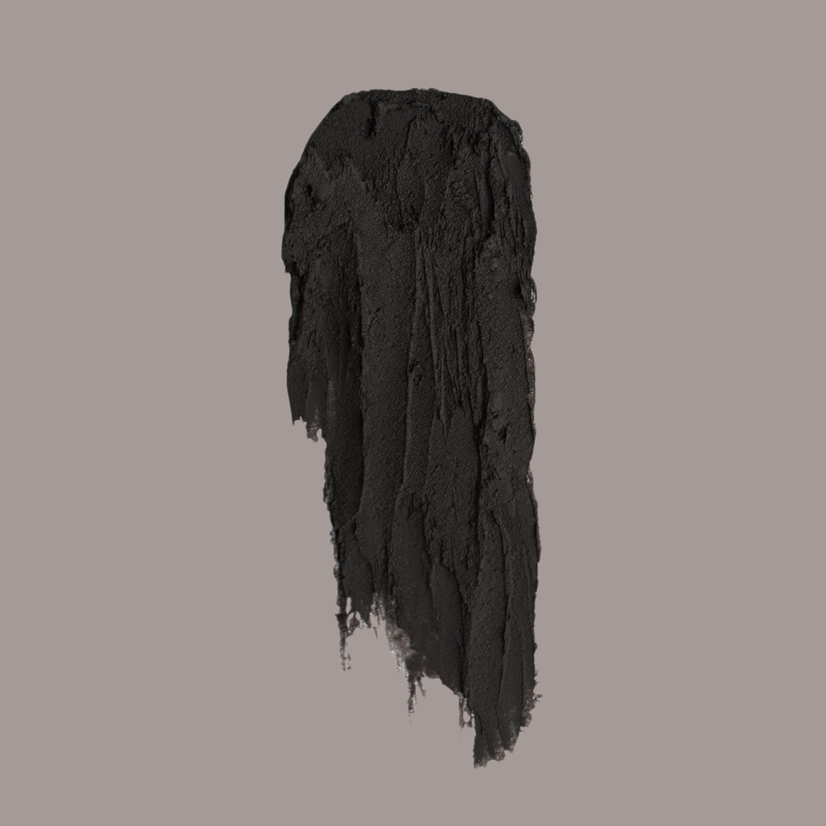 Ein schwarzer Strich des „The Conjuring Matte Lipstick“ von Lethal Cosmetics auf einem schlichten hellgrauen Hintergrund.