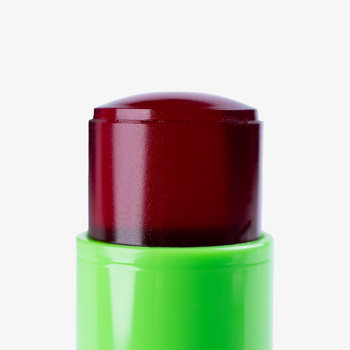 Eine Nahaufnahme des dunkelroten The SpongeBob Movie Jelly Blush Stick "Mr. Krabs" von Lethal Cosmetics in einem leuchtend grünen Drehstift vor weißem Hintergrund.