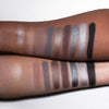 Zwei Arme mit unterschiedlichen Hauttönen präsentieren schimmernde und matte Farbtöne aus der Aim Higher Palette von LH Cosmetics.