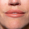 Nahaufnahme der Lippen einer Person mit nudefarbenem LH Cosmetics Crayon Bite.