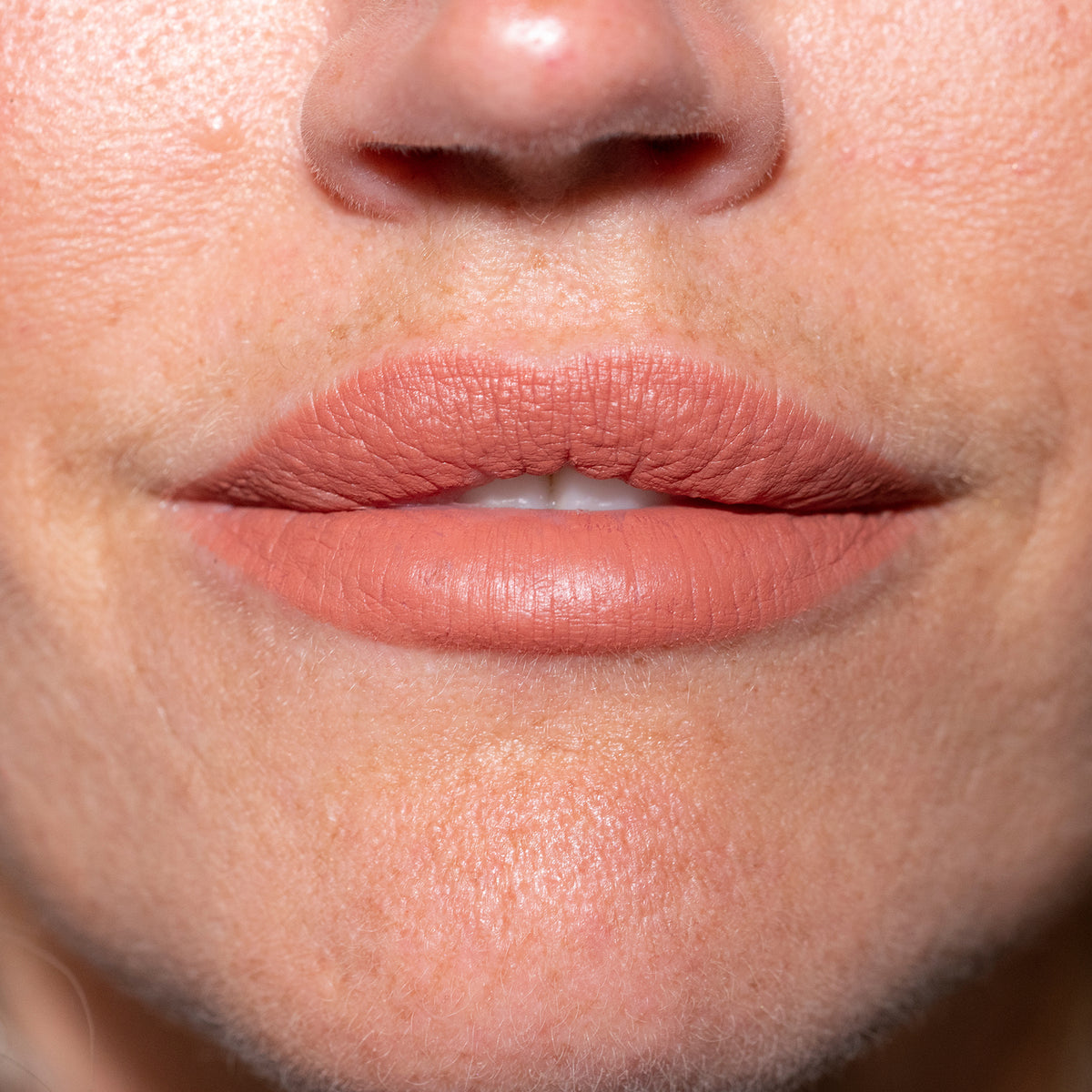 Nahaufnahme der Lippen einer Person mit nudefarbenem LH Cosmetics Crayon Bite.