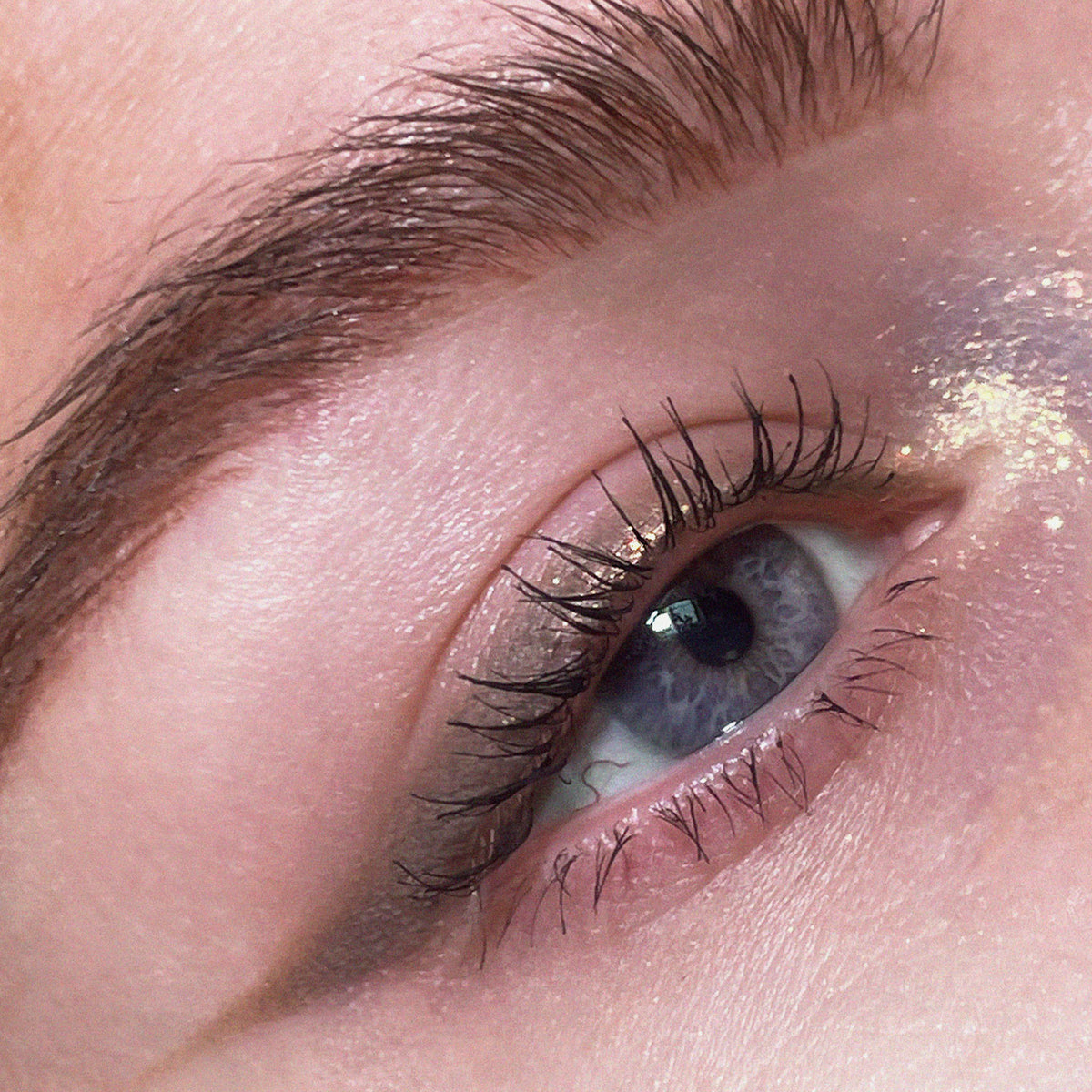 Nahaufnahme eines Auges zeigt einen kreativen grau-beigen Eyeliner, der mit dem Crayon Greige von LH Cosmetics kreiert wurde.