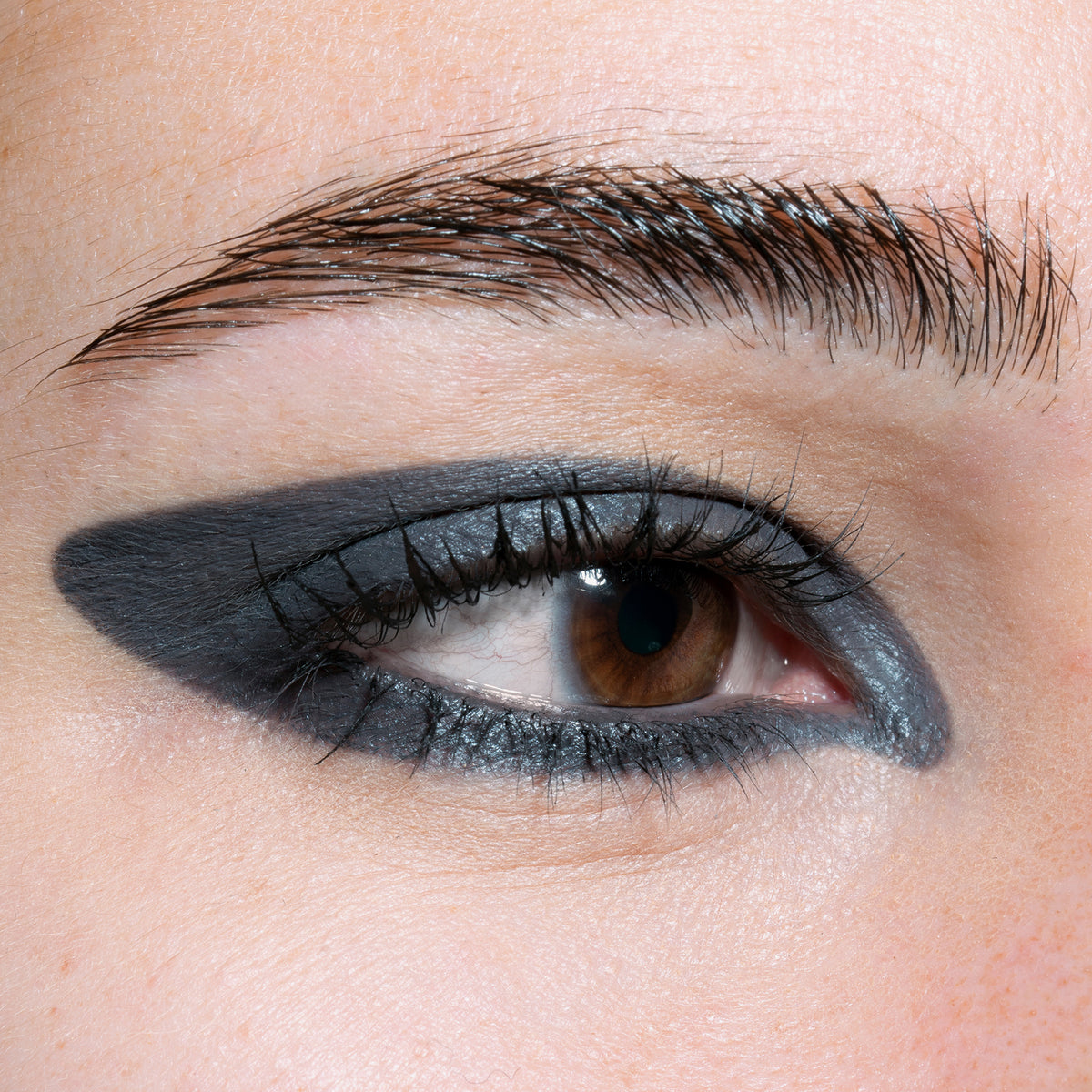 Nahaufnahme eines Auges zeigt einen kreativen grauen Eyeliner, der mit dem Crayon Grey von LH Cosmetics kreiert wurde.