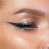 Nahaufnahme eines Auges mit glitzerndem Eyeliner und Augenlid. Look kreiert mit dem Sparkl Flash.