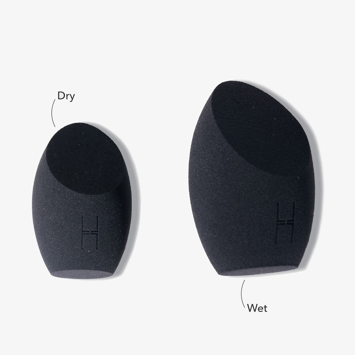 Auf weißem Hintergrund sind zwei schwarze Make-up-Schwämme „The Other Sponge“ von LH Cosmetics mit der Aufschrift „Dry“ (kleiner) und „Wet“ (größer) abgebildet.
