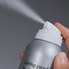 Eine Hand drückt mit silberner Sprühdose das Living Proof Perfect Hair Day Advanced Clean Dry Shampoo in die Luft.