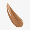 Nahaufnahme der cremigen braune Textur des Lumene INVISIBLE ILLUMINATION Glow Beauty Serum Universal Bronze.