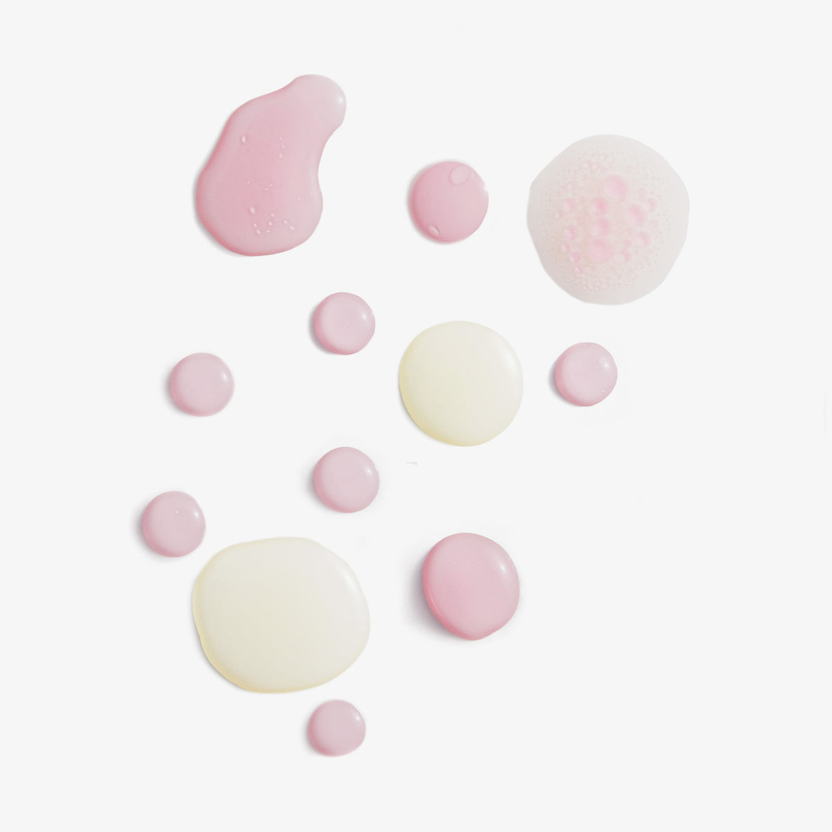 Rosane und beige Tropfen des Lumene NORDIC-C [VALO] Arctic Berry Multivitamin Cocktail Oil auf weißem Hintergrund.