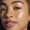 Nahaufnahme einer Person mit strahlender, taufrischer Haut und natürlichem Make-up, das mit dem Lumene NORDIC-C [VALO] Essence + Oil-Cocktail Duo Set erzielt wurde. 