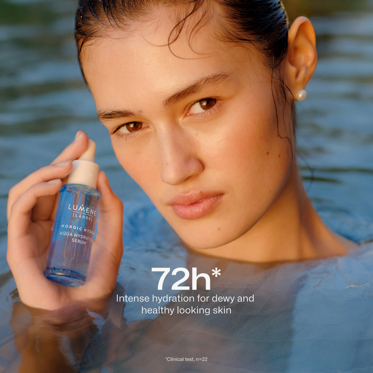 Eine Frau im Wasser hält Lumene Nordic Hydra [LÄHDE] Aqua Hydration Serum in der Hand; der Text lautet: "72h* intensive Feuchtigkeitszufuhr für taufrische, gesund aussehende Haut."