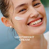 Lächelnde Frau mit Nordic Hydra [LÄHDE] Intense Hydration Moisturizer auf der Wange und dem Schriftzug "Lightweight Cream".