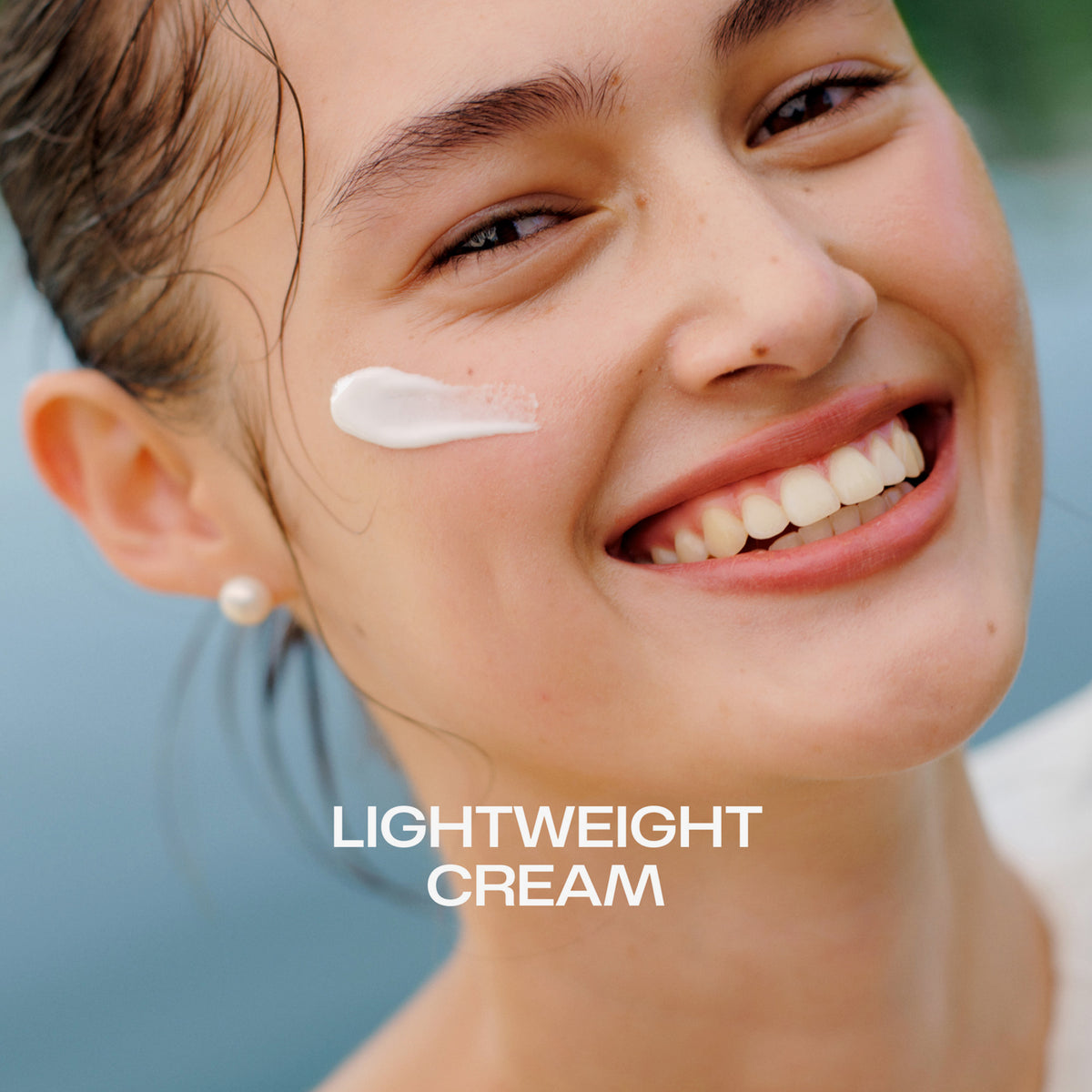 Lächelnde Frau mit Nordic Hydra [LÄHDE] Intense Hydration Moisturizer auf der Wange und dem Schriftzug "Lightweight Cream".