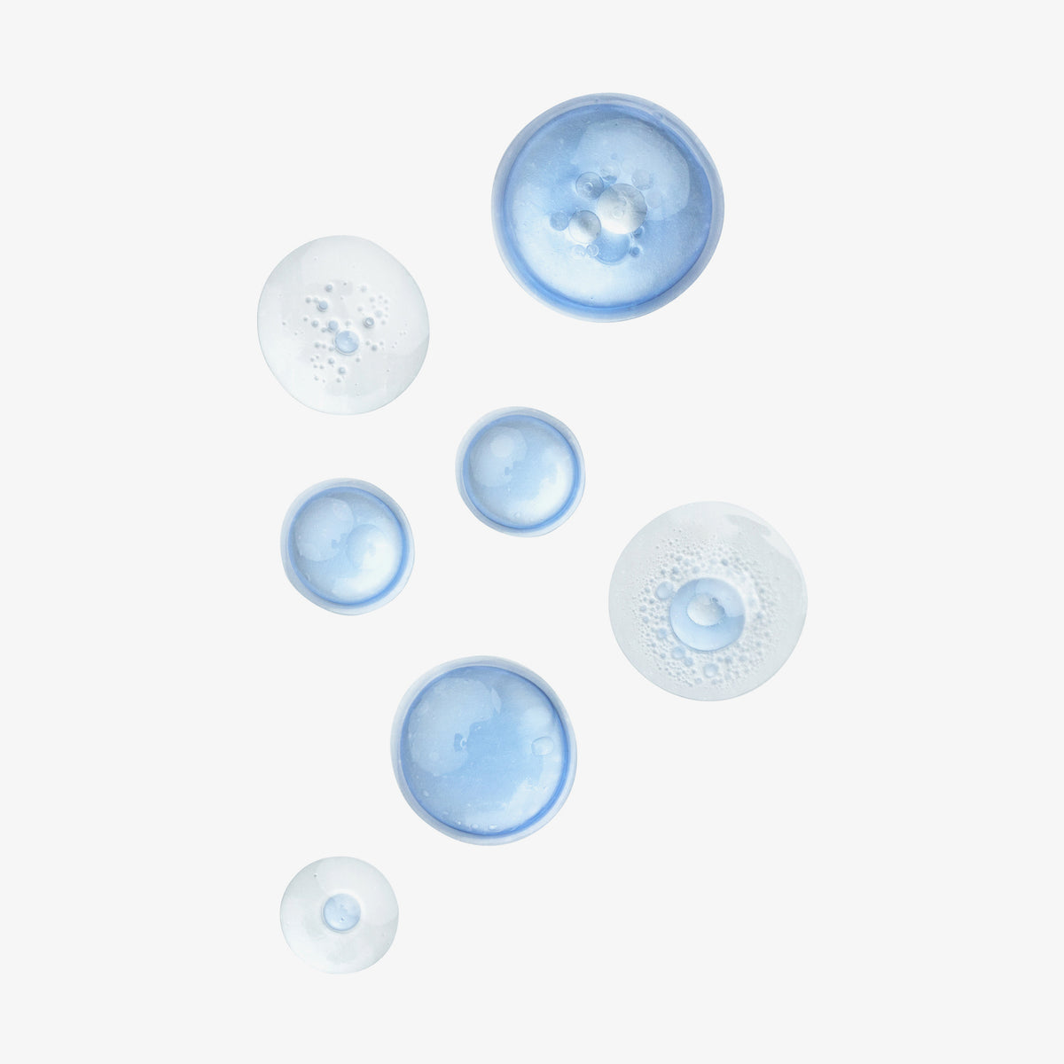 Durchscheinende blaue und klare Tropfen des Lumene NORDIC HYDRA [LAHDE] Moisturizing Prebiotic Oil-Cocktail auf weißem Hintergrund.