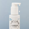 Eine weiße Lumene NORDIC HYDRA [LAHDE] Oat Milk Oil Cleanser Pumpflasche mit einem weißen fallenden Tröpfchen vor einem hellblauen Hintergrund.