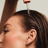 Eine Person trägt das maria nila Head & Hair Heal Soothing Serum mit einer Pipette auf ihre Kopfhaut auf.