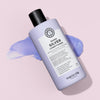 Eine lavendelfarbene Flasche maria nila Sheer Silver Conditioner steht auf einem hellvioletten Hintergrund, akzentuiert durch einen Streifen lila Conditioner.