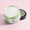 Geöffneter Tiegel von maria nila Structure Repair Masque mit cremig weißem Produkt auf hellrosa Hintergrund.