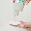 Eine Hand gießt Mario Badescu Hydrating Glow Toner aus einer weißen Flasche auf ein rundes Wattepad.