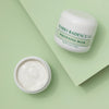 Zwei Tiegel der Mario Badescu Whitening Mask stehen auf einem hellgrünen Hintergrund, von denen einer geöffnet ist, um die Creme darin zu zeigen.