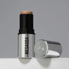 Der silberne Make-up-Stift The Mood Contrast 101 Light von Mesauda neben silberner Kappe auf grauem Hintergrund.