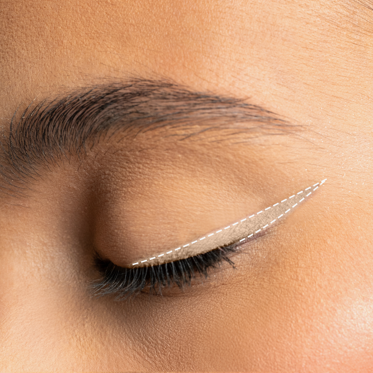 Augen-Make-up mit beigen Winged Eyeliner in tiefem Schwarz, präzise aufgetragen und mit feiner weißer Linie akzentuiert.