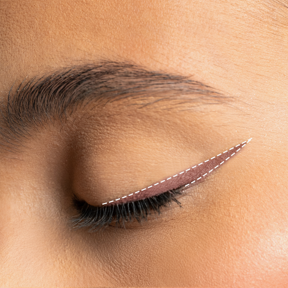 Augen-Make-up mit mauve-pinkem Winged Eyeliner in tiefem Schwarz, präzise aufgetragen und mit feiner weißer Linie akzentuiert.