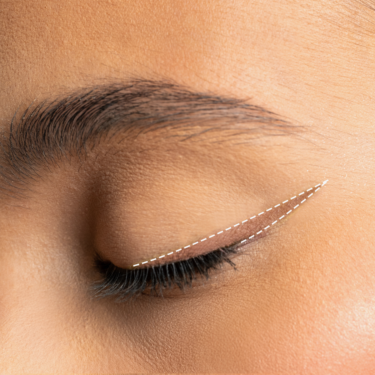 Augen-Make-up mit nudefarbenem Winged Eyeliner in tiefem Schwarz, präzise aufgetragen und mit feiner weißer Linie akzentuiert.