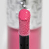 Nahaufnahme des Blushapplikators; darauf ein Tropfen Flush of Blush Petal Pink mit strukturierter silber Kappe im Hintergrund.