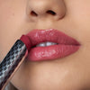 Nahaufnahme einer Person die den Hydramorphosis Lippenstifts von Mesauda Beauty trägt und den Lippenstift an den Mund hält.