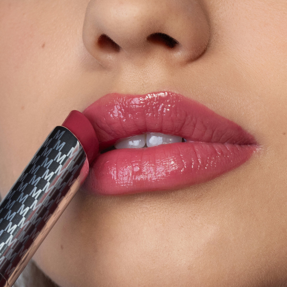 Nahaufnahme einer Person die den Hydramorphosis Lippenstifts von Mesauda Beauty trägt und den Lippenstift an den Mund hält.