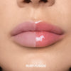 Nahaufnahme der Lippen: links nackt, rechts glänzend rosa, darunter der Farbname "RUBY FUSION" von LIPOILOGY™ by Mesauda Beauty.
