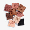Das Bild zeigt neun einzelne, quadratische Lidschattenpfännchen in verschiedenen Tönen der Side By Side Nude Palette Baby mit Nude-, Rosa-, Braun- und Schwarztönen auf weißem Hintergrund.