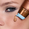 Nahaufnahme eines Frauengesichts, während die NABLA Cosmetics Angel Aura Bronze aus dem Sun-Kissed Glow Set aus der Make-up-Tube auf ihre Wange aufgetragen wird.